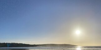 Image of beach with rocks and the sun shining